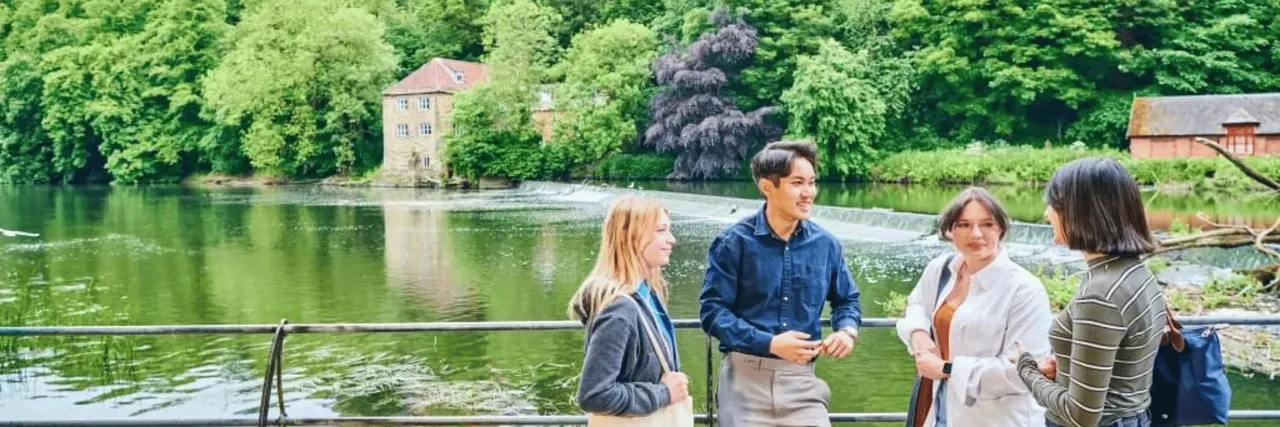 Students chatting by the Durham riverside