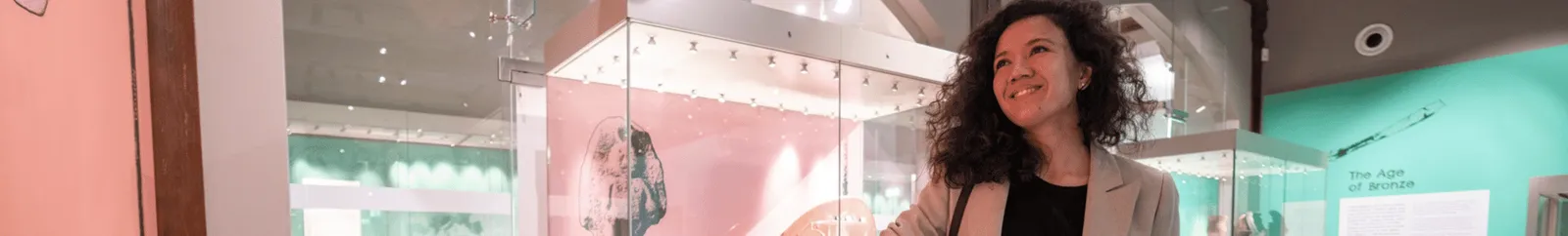 A woman examining an exhibit in the Museum of Archaeology