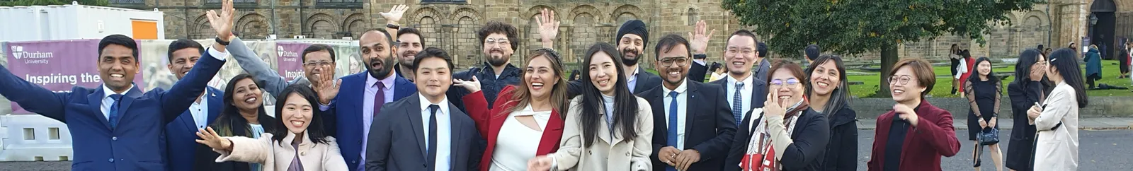 A large group of male and female students outside Durham Cathedral