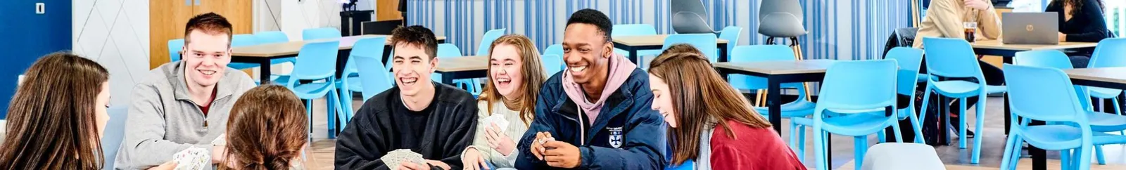 A mixed group of students chatting in a college bar