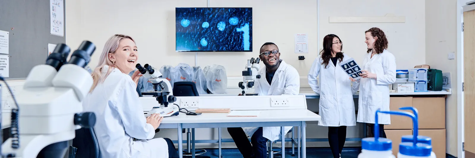 A group of students in a laboratory with microscopes