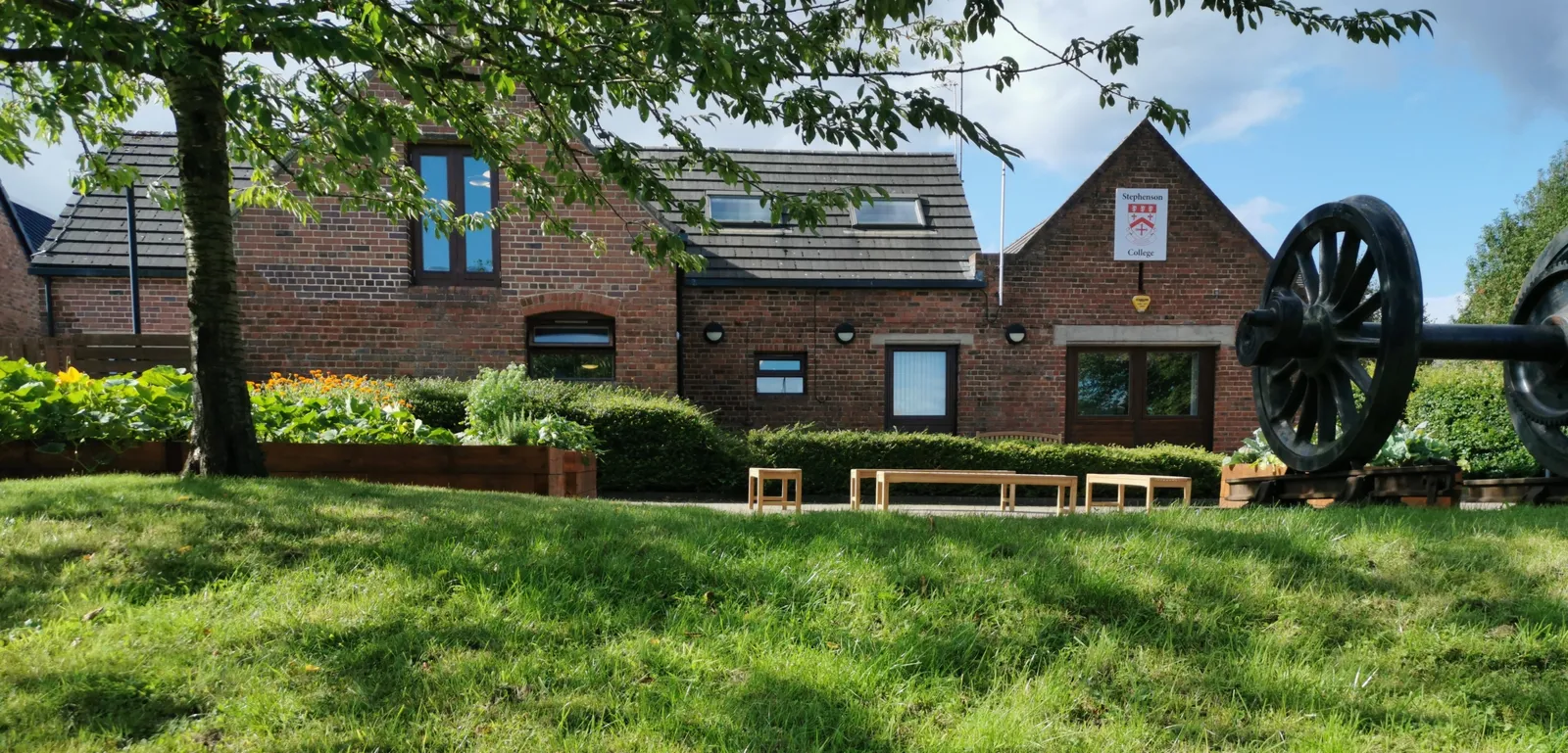 Stephenson College featuring our vegetable garden and train wheels