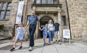 A family exiting Palace Green Library.