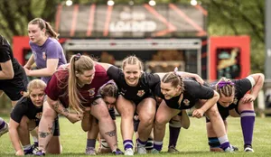 Members of the women's rugby team practicing scrum formation