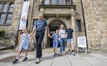 A family exiting Palace Green Library..