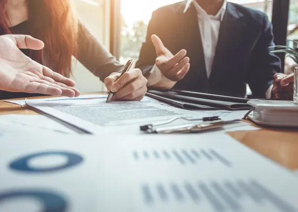 Close-up of two people working at a meeting table