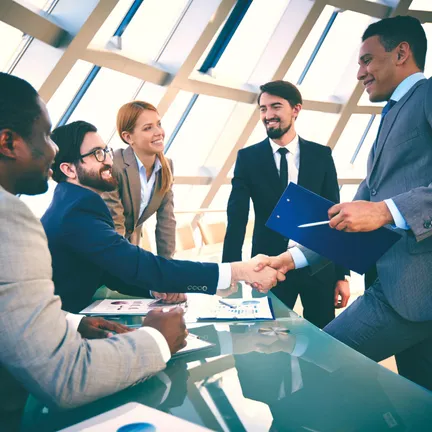 A group of business people shaking hands across a table