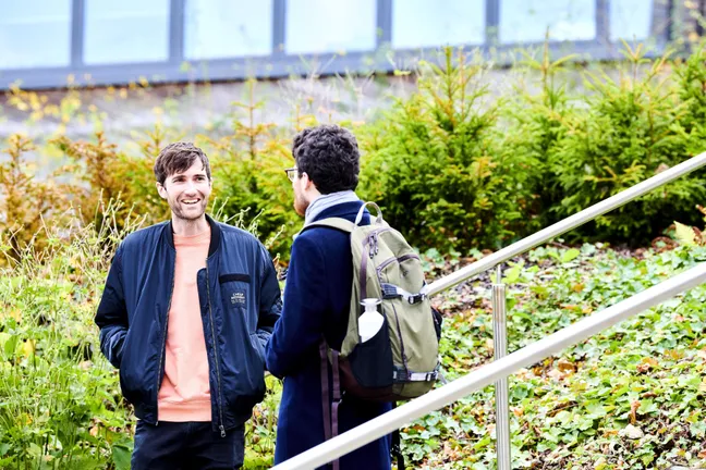 Picture shows two students in conversation outdoors on our campus