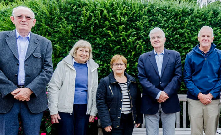 A group of retired staff members standing outside