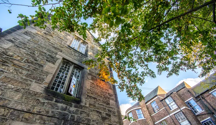 Looking up at an open window on a college building