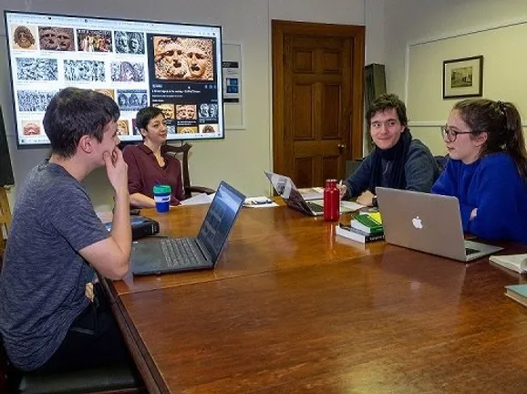 Students sitting round a table with laptops