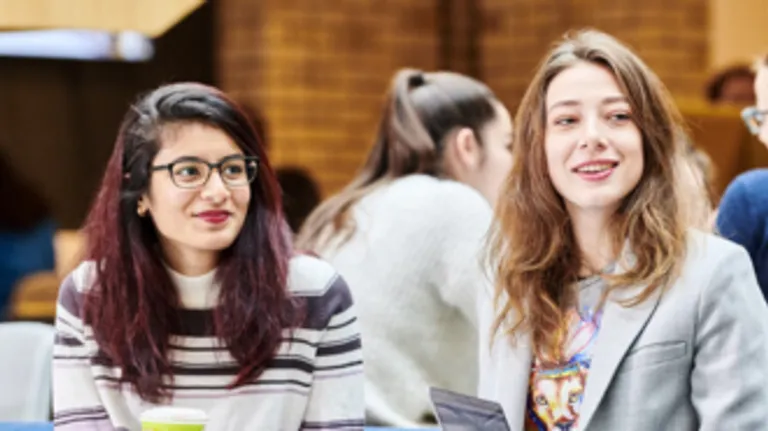 Two female students sitting side by side.
