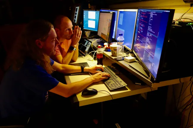 2 people working in telescope at night