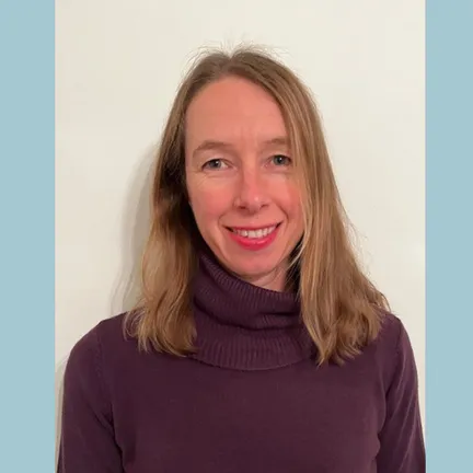 Emma Cave is pictured in a dark red jumper against a blue background