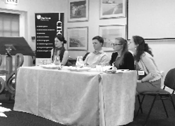 black and white photograph of people sitting behind a table at a conference