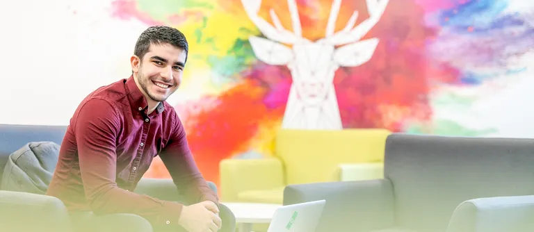 A student sitting in front of a banner