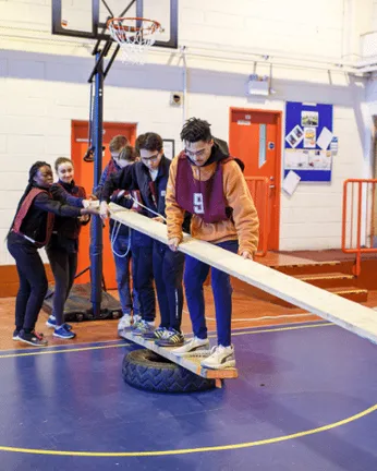 Group of students balancing holding a plank
