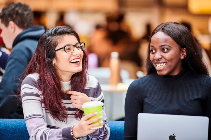 Two students studying in Teaching and Learning Centre with hot drink