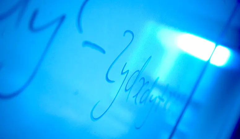 A mathematical equation on a wipe board