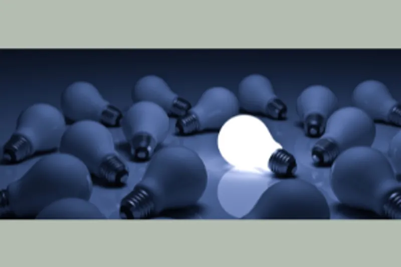 Lit bulb among dark bulbs illustrating leadership