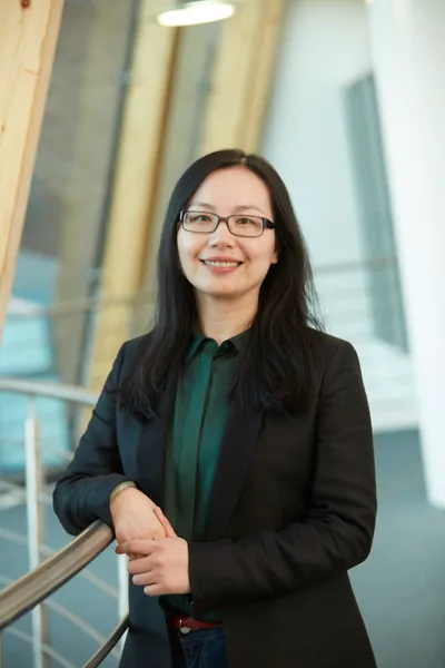 Li Ding wearing green shirt and black blazer in professional setting