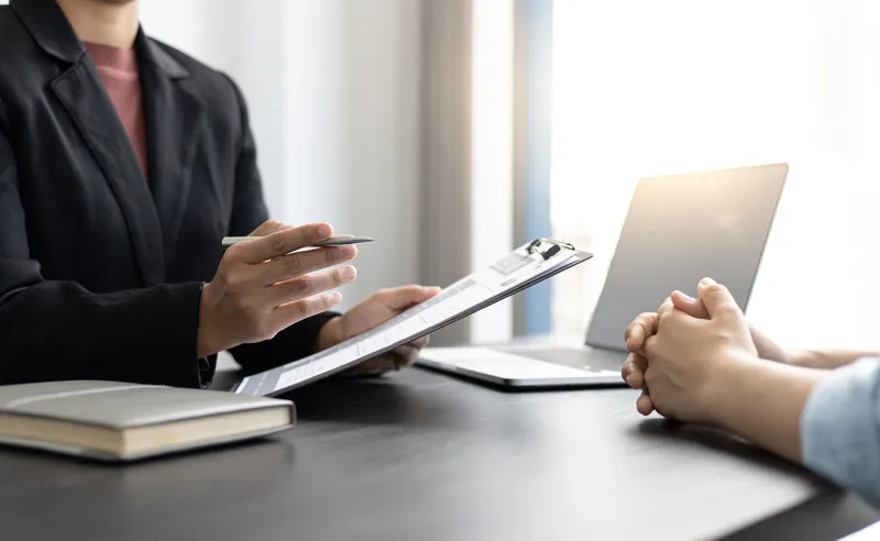 Two people speaking across a desk