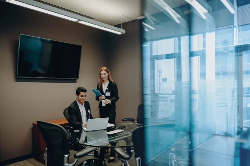 Two business people around a table with laptops