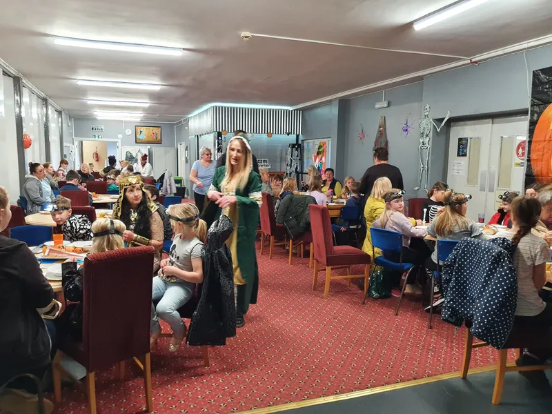 Families seated around tables and engaging in activities at the Hands On History Day as part of the Street Museum project.
