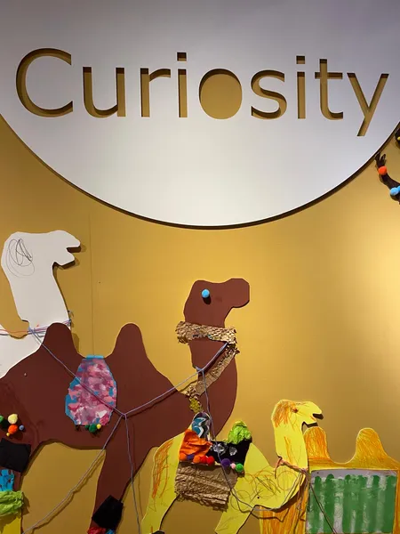 Image from Weaving Stories exhibition showing the title Curiosity and collaged camels