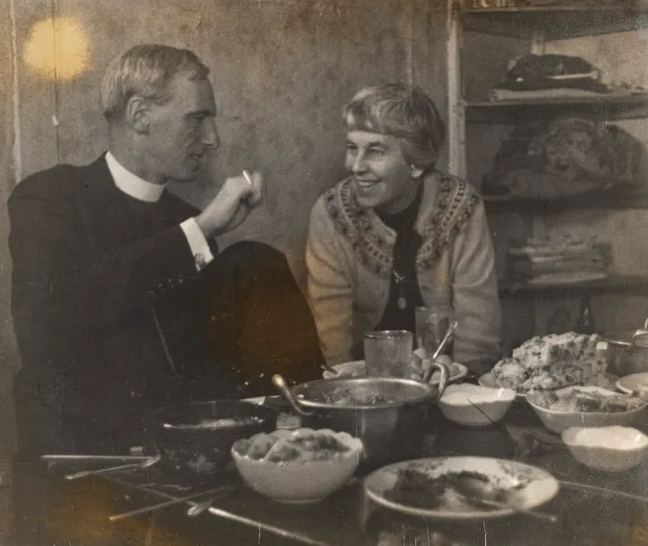 man and a woman sit at a table covered with bowls of food