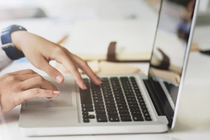 Close up of hands typing on a laptop
