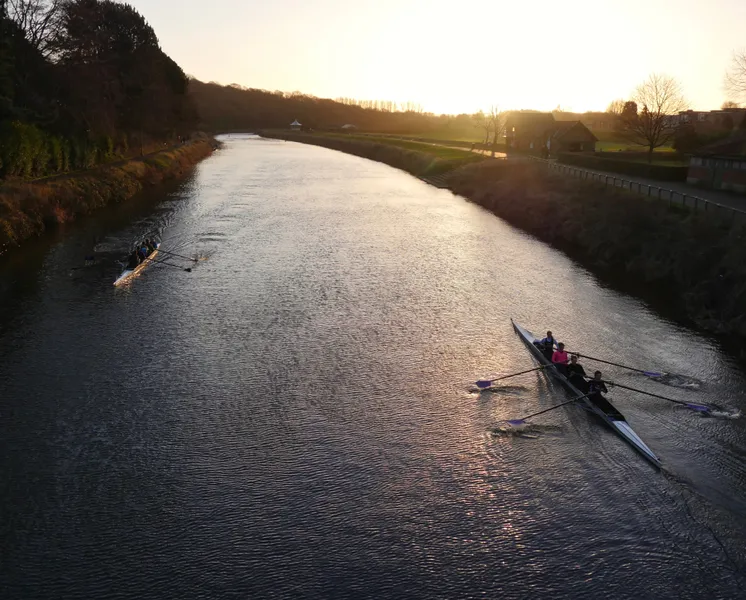 Silhouettes of two boats of rowers on the River Wear
