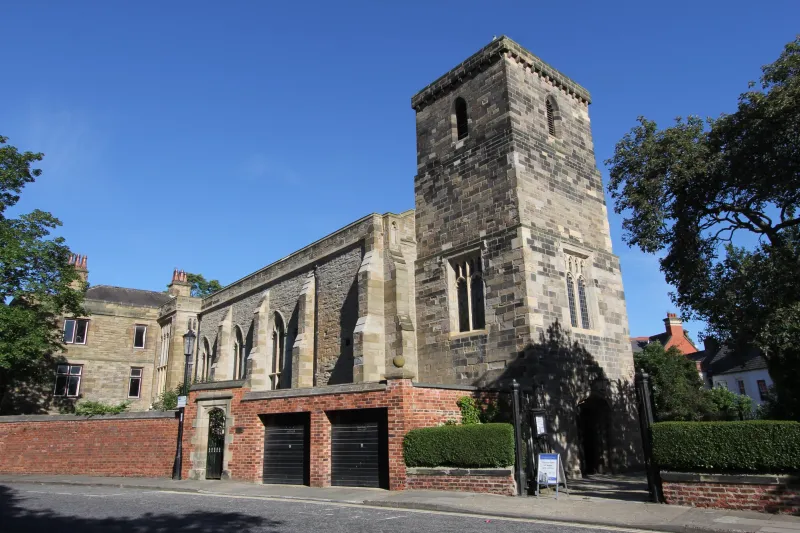 St Cuthbert's Catholic Church in Durham viewed from across the street, framed against a clear blue sky.