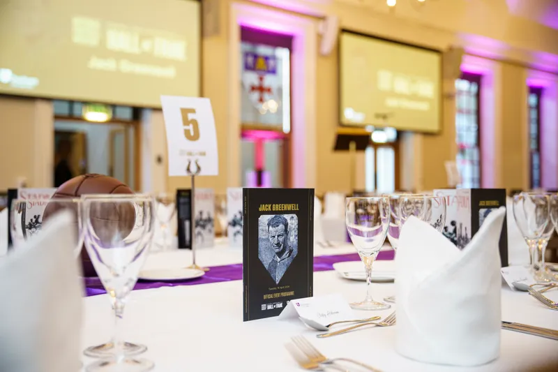A close-up of the table set-up at the Hall of Fame event, including the front cover of the Jack Greenwell official event programme