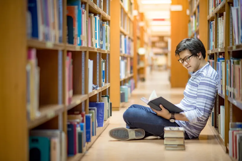 Man reading book in library