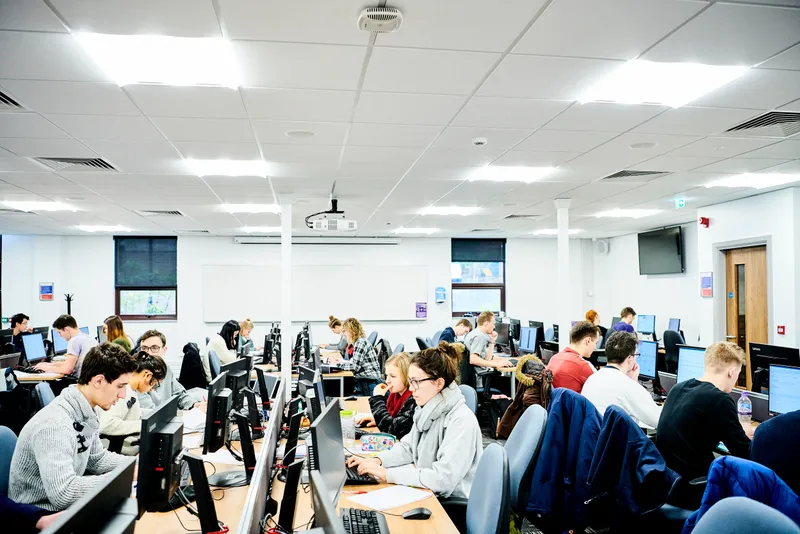 Students working at computers in a study room.