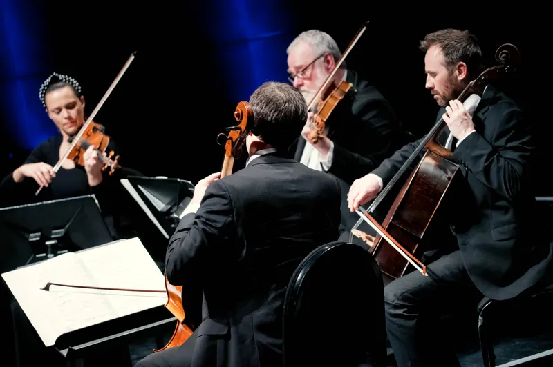 A group of string players performing together