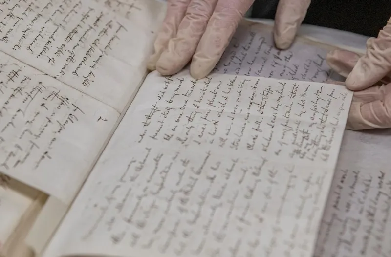 Gloved Hands holding handwritten book