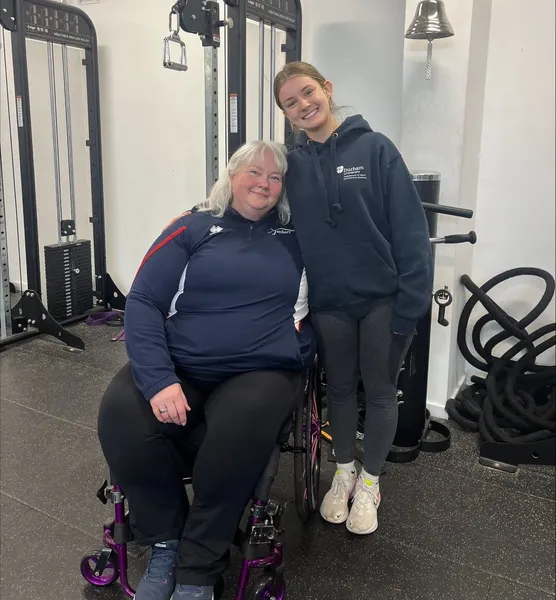 Jodie Newman posing with Paralympian in a gym