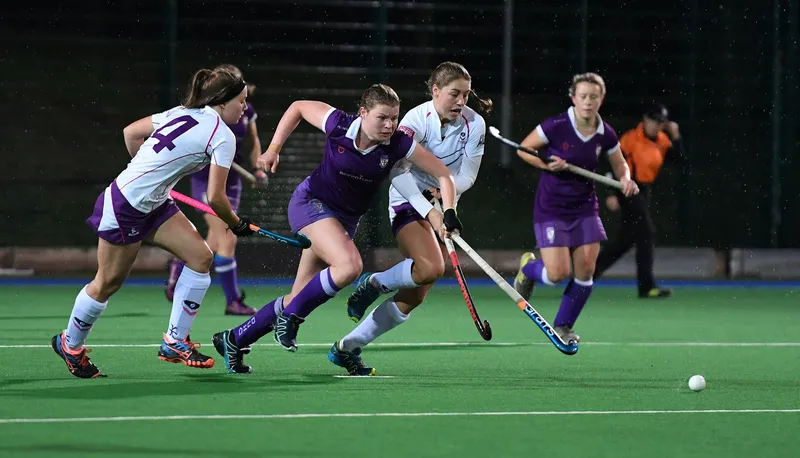 Two teams playing hockey with one player out in front with the puck
