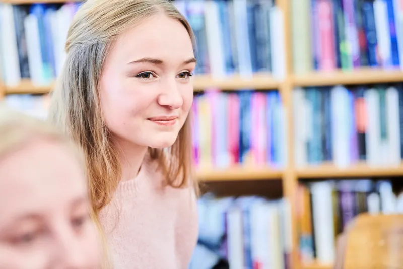 Students sitting in the library, listening to a talk
