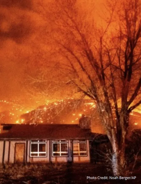 House with wildfire behind it. Photo Credit: Noah Berger/AP
