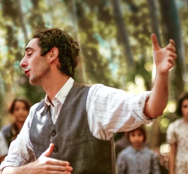 Man telling a story with children watching