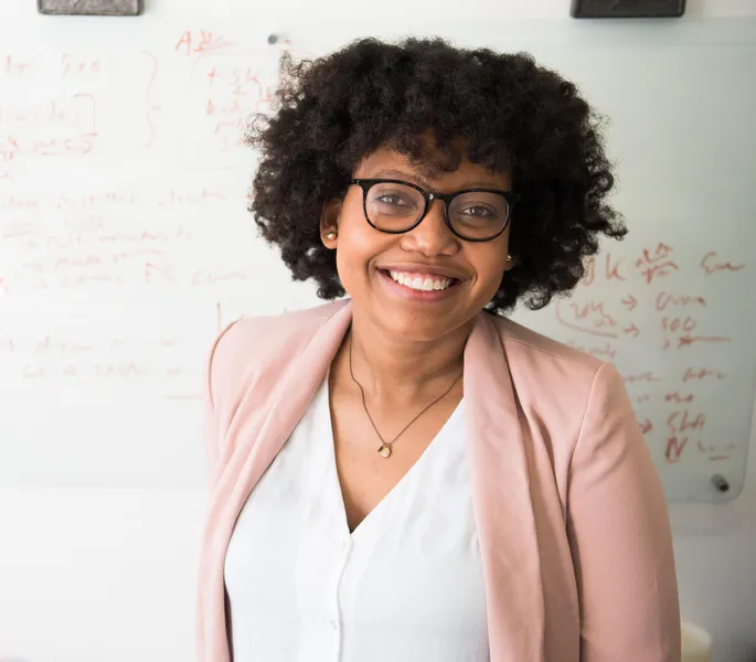 Woman in front of whiteboard smiling