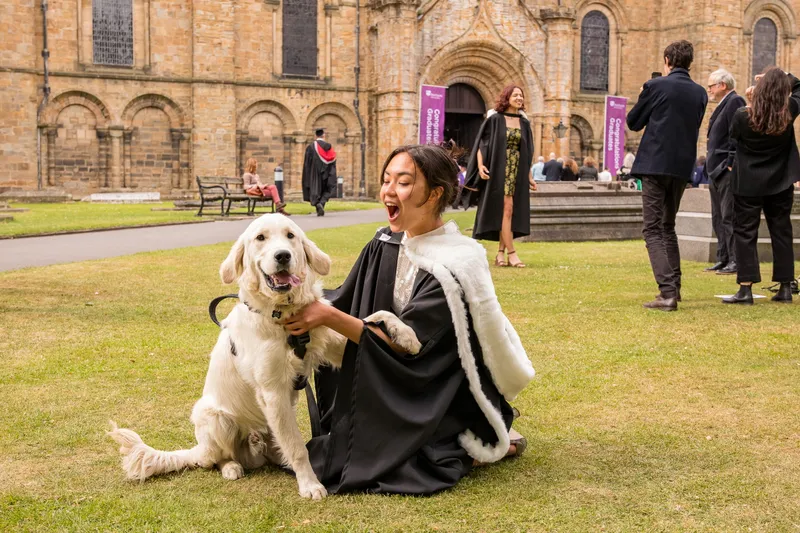 Graduate in robes with dog