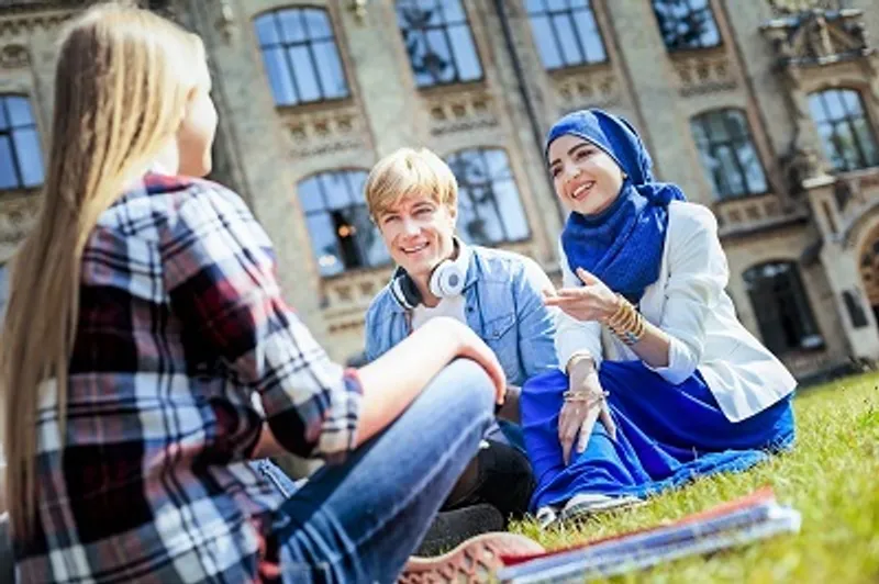 Three students talking while sitting outside