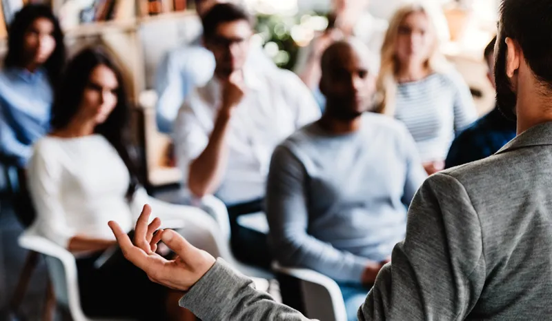 A lecturer speaking to a room full of mature students