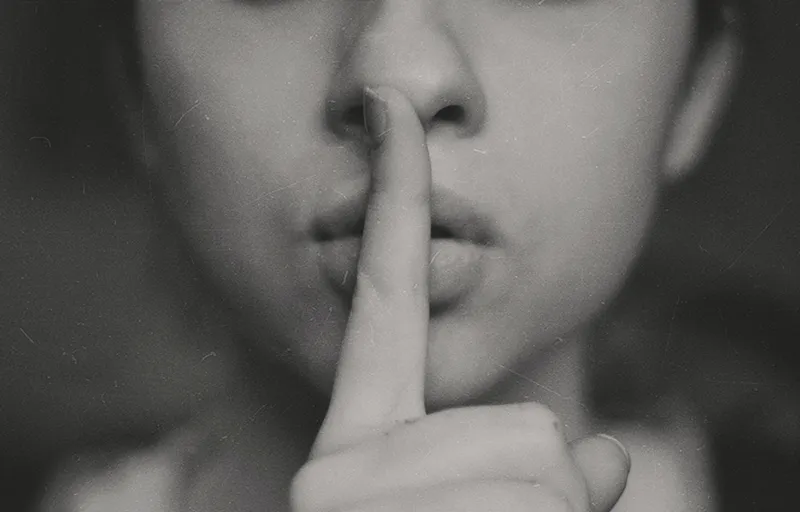 Face image with finger to lips