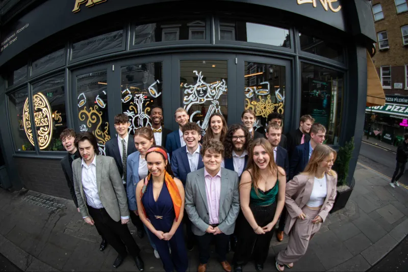 Durham University Big Band pose for a photo outside Pizza Express Soho jazz club