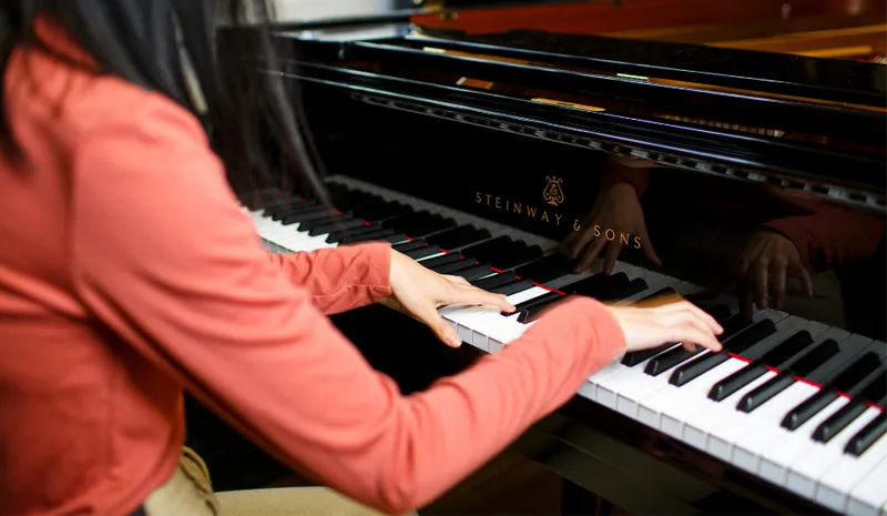 Hands playing Steinway piano